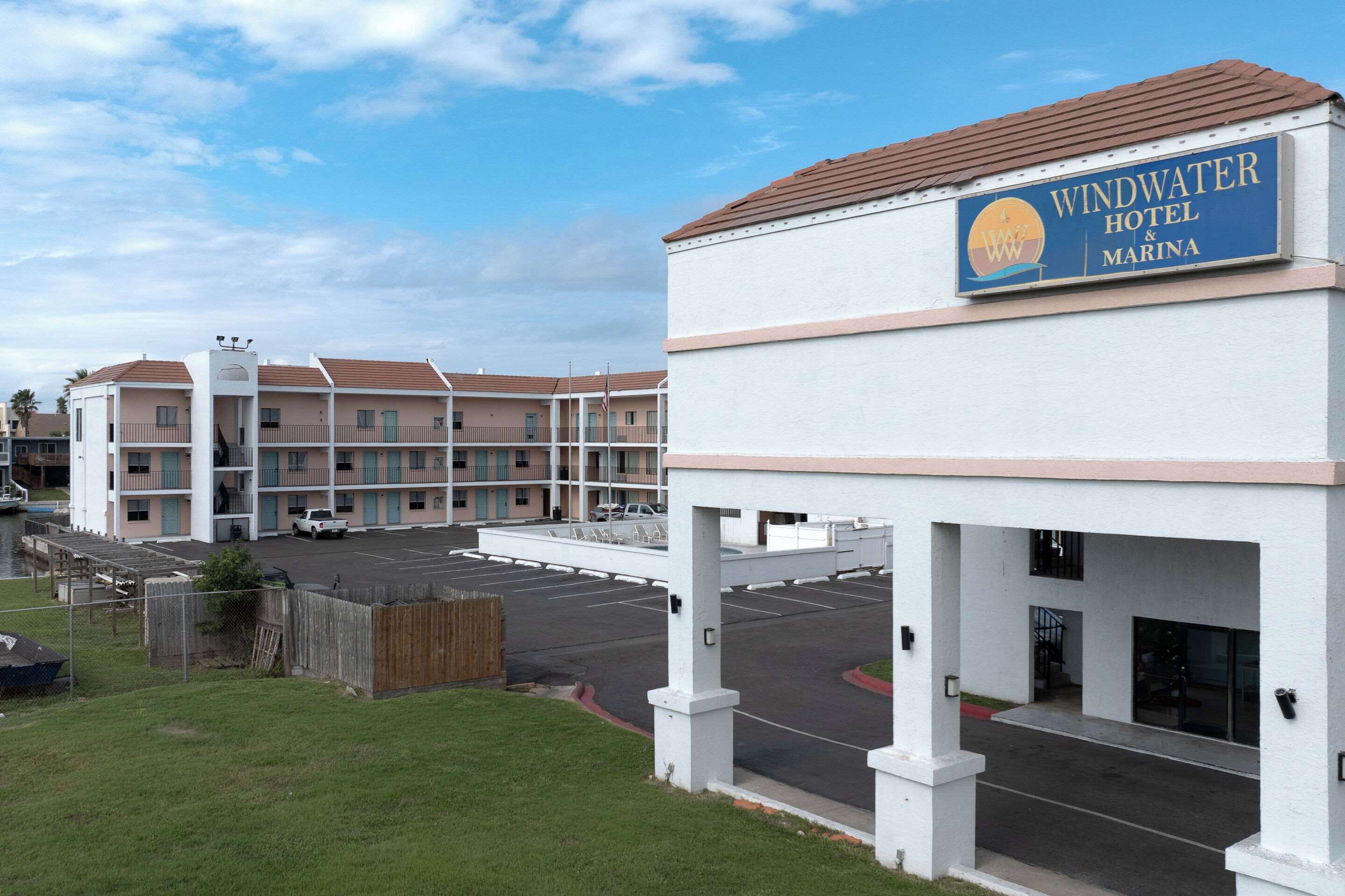 A Windwater Hotel & Marina with a parking lot and a grassy area in front.