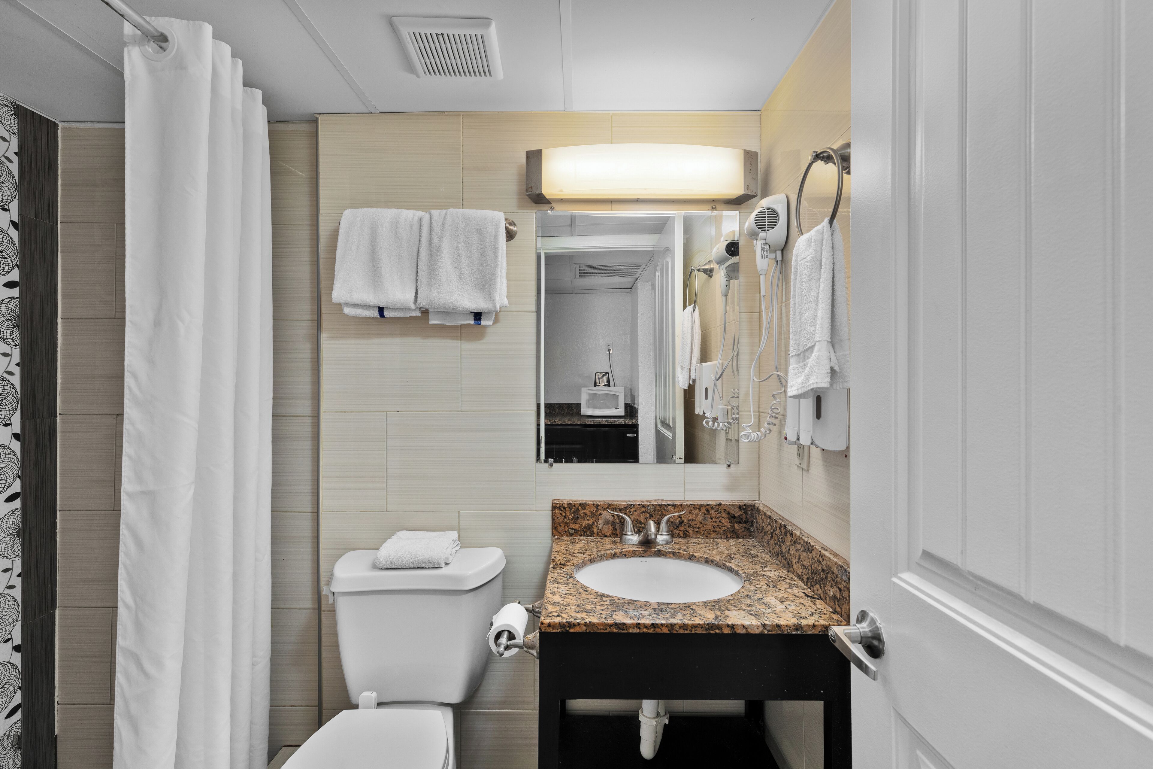 A bathroom with a toilet, sink, and shower.