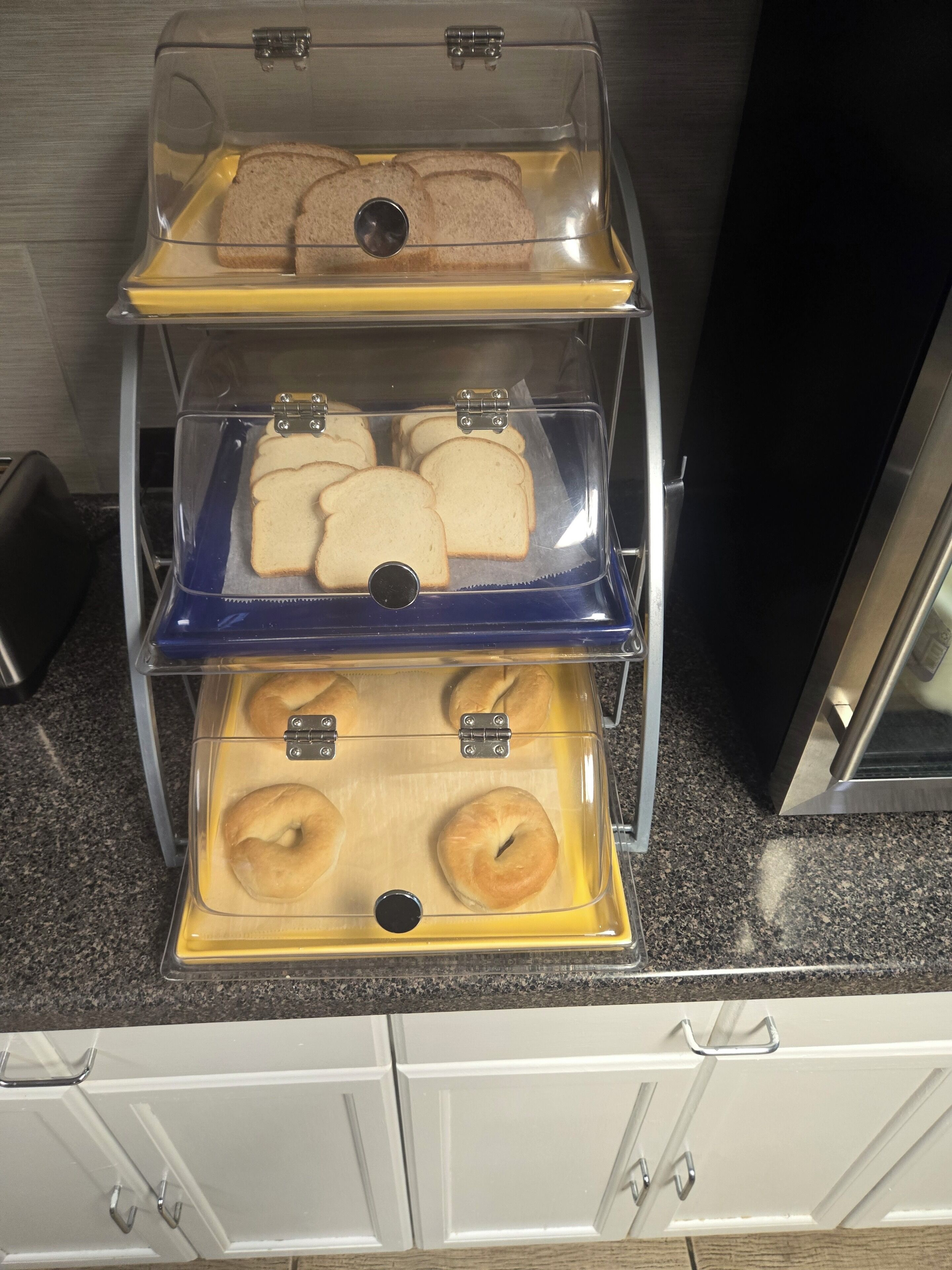 A breakfast display with bread and bagels.