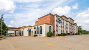 A hotel with a brick facade, multiple windows, and a parking lot. - Baymont by Wyndham Festus (Festus)