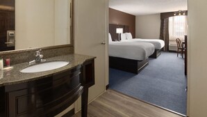 A hotel room with a bathroom, a bed, a desk, and a chair. - Baymont by Wyndham Festus (Festus)