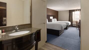 Une chambre d’hôtel avec une salle de bain, un lit, un bureau et une chaise.