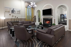 Una sala de estar moderna con un sofá seccional, una mesa de centro de vidrio y una chimenea.