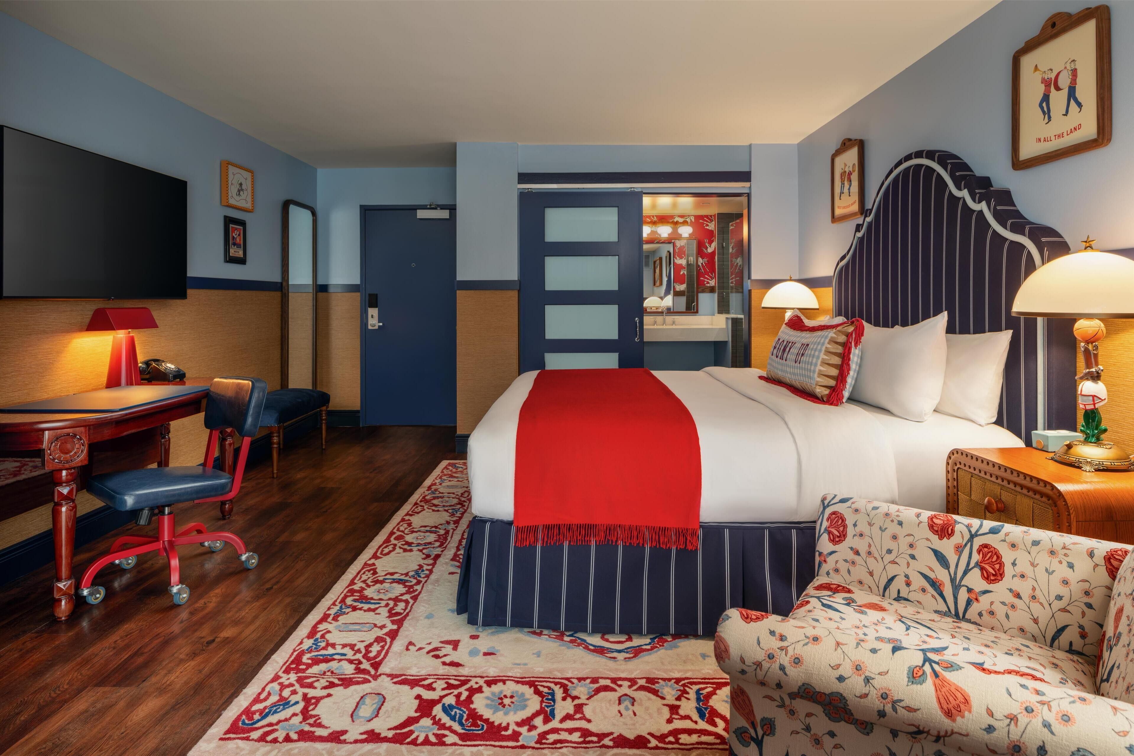 Een hotelkamer met een bed, bureau, stoel, bank en televisie.