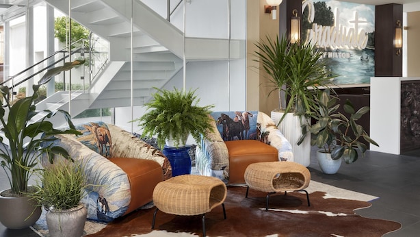 A modern interior with a staircase, seating area, and a large painting. - Graduate by Hilton Dallas (Dallas)
