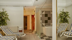 Un baño con piso a cuadros, una bañera y dos sillones a rayas.