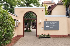 Una entrada con un cartel que indica recepción y jardín de cerveza, e indicaciones para Reichelbräu Keller.
