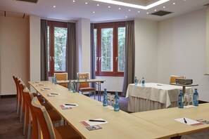 Une salle de conférence équipée d’une longue table, de chaises et d’un projecteur.