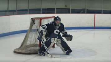 Un portero de hockey en un área con red, probablemente durante un entrenamiento o sesión de práctica.