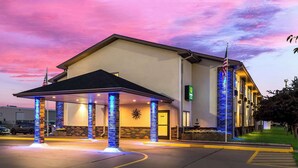 A hotel with a covered entrance, a brick facade, and an American flag.