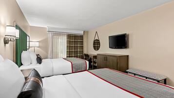 Une chambre d’hôtel avec deux lits, un bureau, une chaise, une télévision et une fenêtre avec des rideaux.