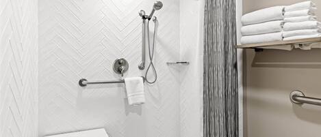 A modern bathroom with a shower, a towel rack, and a toilet.