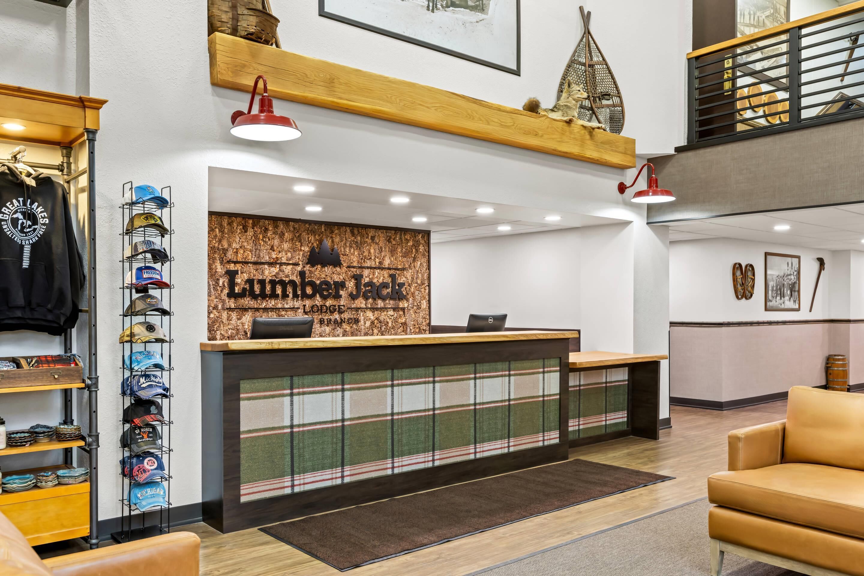 Un mostrador de recepción con un cartel que dice "Lumberjack Lodge" y una colección de sombreros en estantes a la izquierda.