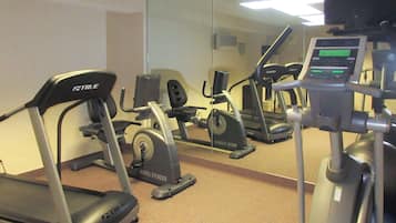 A hotel fitness center with treadmills, elliptical machines, and a stationary bike.