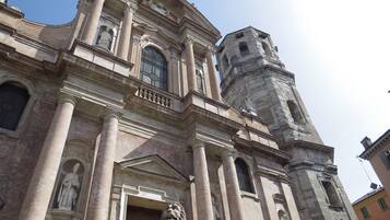 A historic building with classical architecture, featuring columns, statues, and a prominent bell tower.