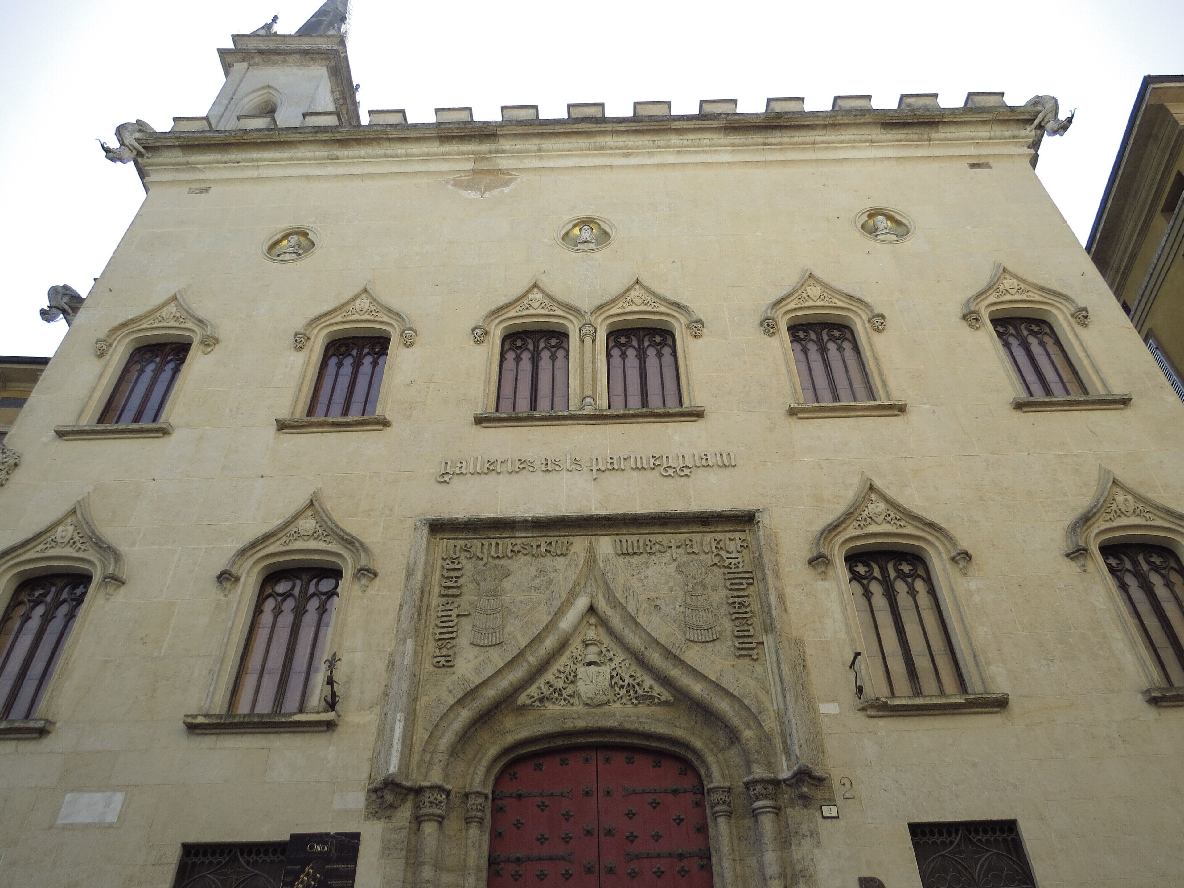 A building with a red door and multiple arched windows.