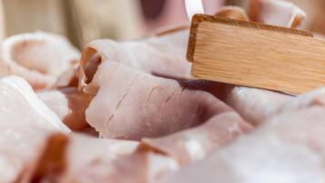 Un primo piano di fette di carne su un tagliere di legno.