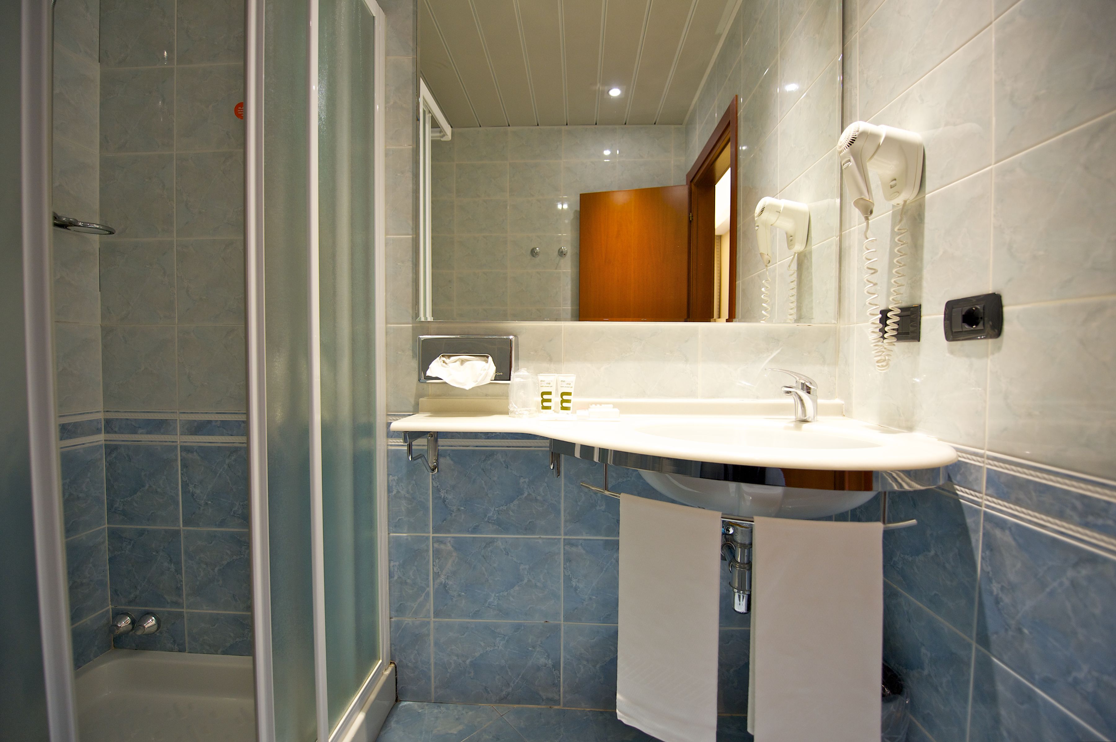 A bathroom with a shower, a sink, and a mirror.