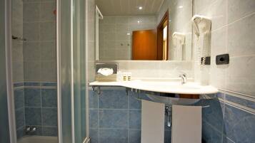 A bathroom with a shower, a sink, and a mirror.