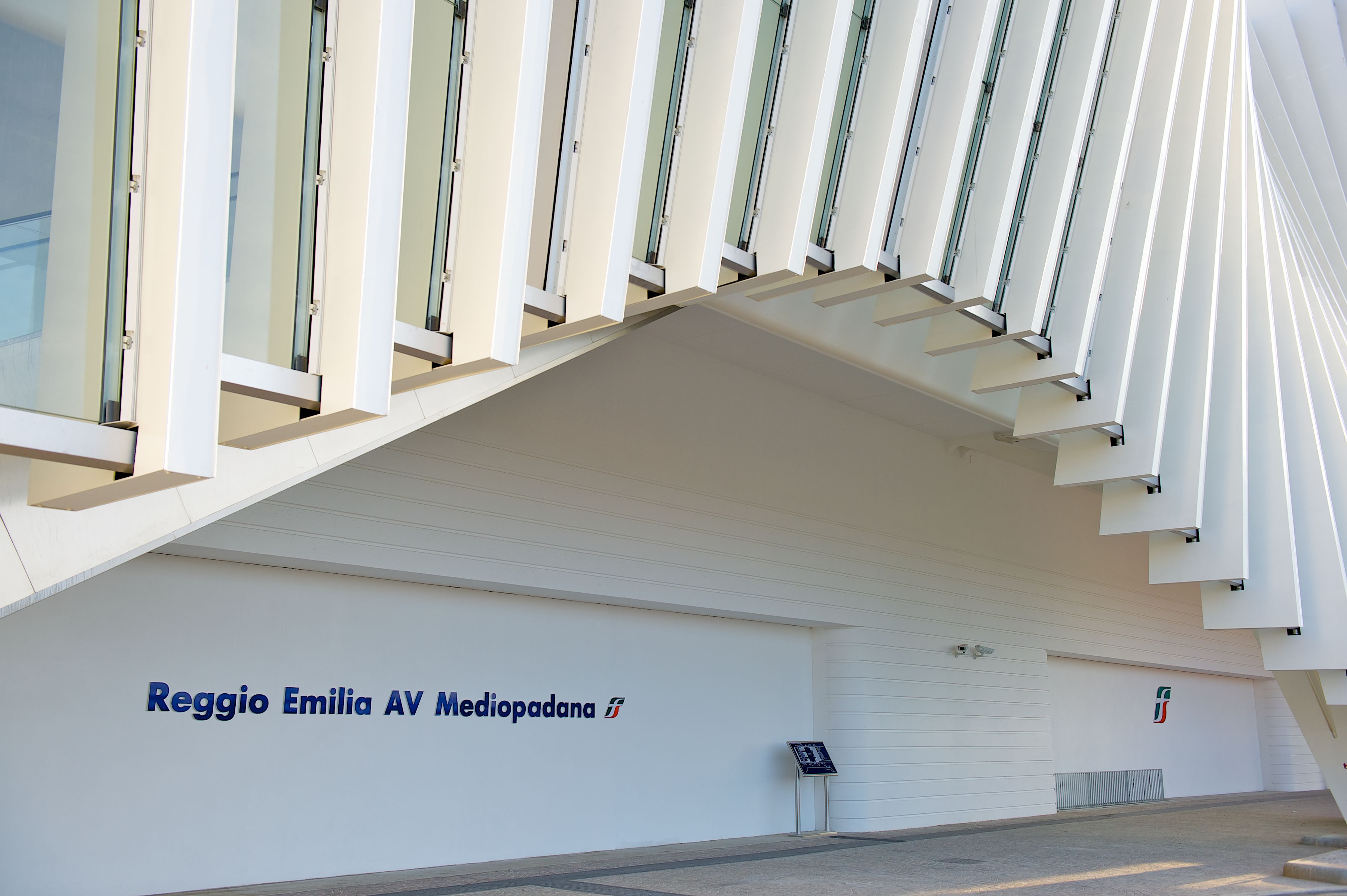Facciata di un edificio dal design moderno, caratterizzata da una serie di finestre verticali e un tetto piatto.