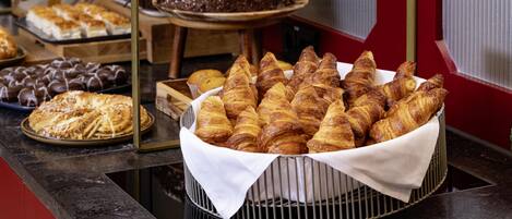 A buffet with various baked goods including pastries and desserts.