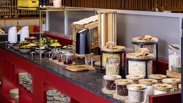 A buffet setup with various food containers and utensils.