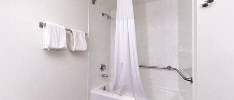 A modern bathroom with a walk-in shower, a bathtub, and a towel rack with two towels.