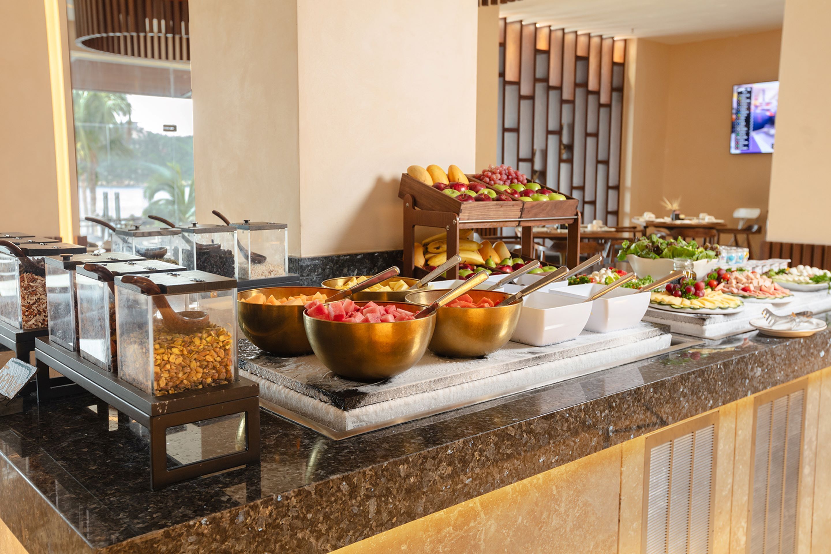 A buffet with various food items including fruits, meats, and cheeses.