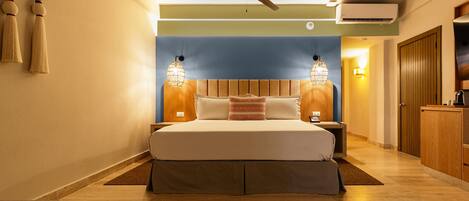 A bedroom with a bed, a ceiling fan, wall-mounted lamps, and an air conditioning unit.