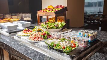 A buffet with various food items including salads, fruits, and dairy products.
