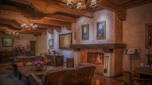 Una sala de estar acogedora con chimenea, muebles de madera y obras de arte en las paredes.