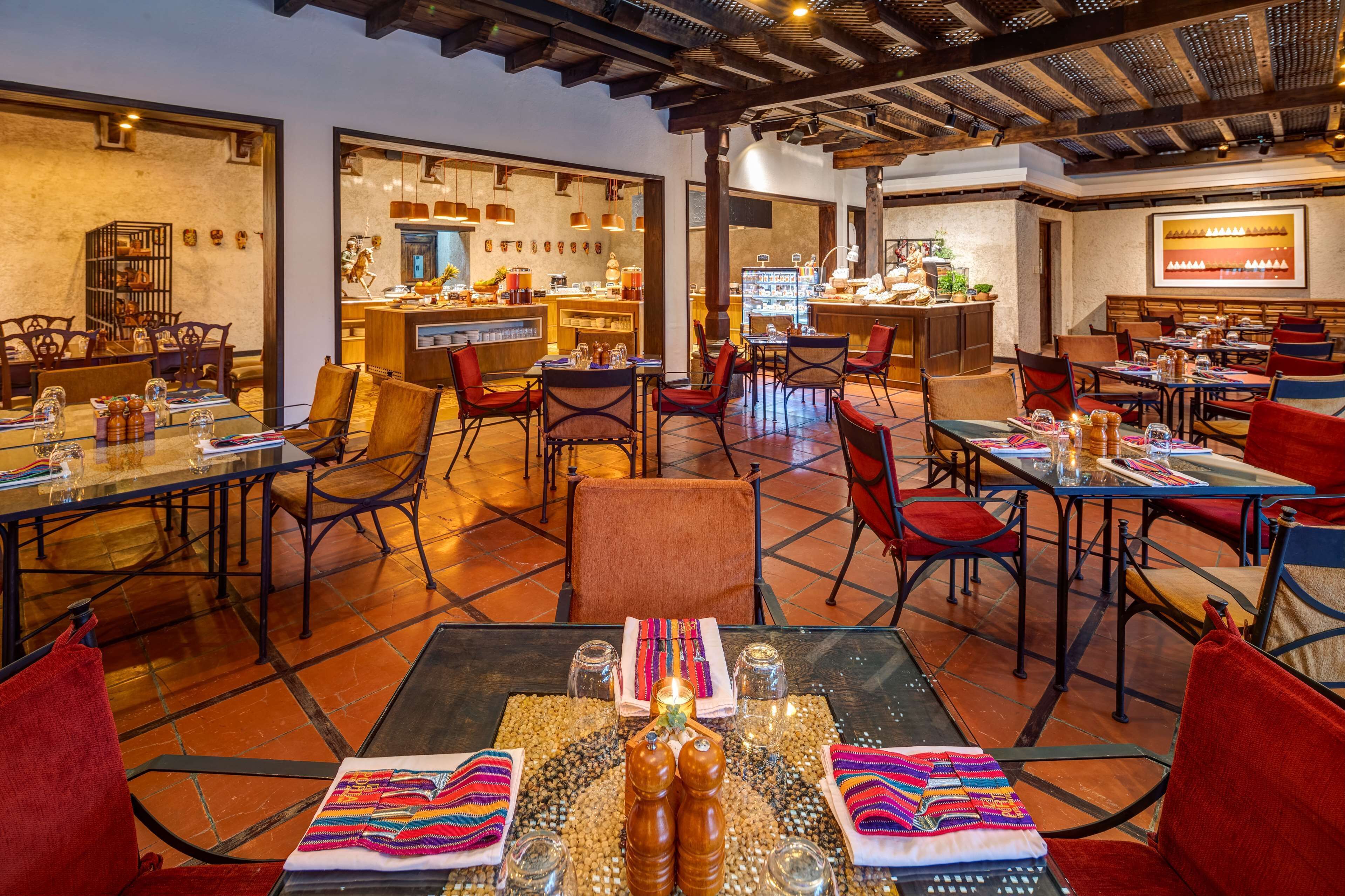 A restaurant with multiple tables and chairs, a bar area, and a tiled floor.