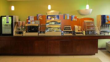 Een ontbijtbuffet met een bord waarop staat dat het geopend is van 6:30 tot 10:00 uur.