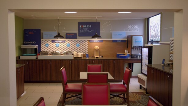 En frukostmatsal på hotellet med en disk, sittplatser och olika matserveringsstationer.