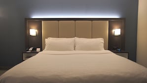 A hotel room with a large bed, two bedside tables, a nightstand, and a wall-mounted lamp. - Holiday Inn Express Anderson by IHG (Anderson)