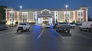 A hotel with a parking lot, multiple vehicles, and a well-lit entrance. - Holiday Inn Express Anderson by IHG (Anderson)