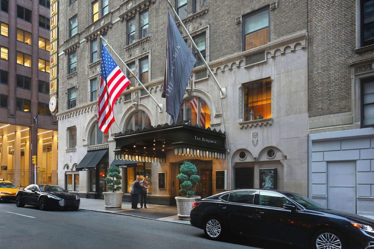 A historic building with a marquee sign, American flags, and a classic architectural style.
