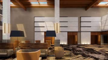 Een ruime lobby met hoge plafonds, zichtbare houten balken en een kamerbreed tapijt met dessin.