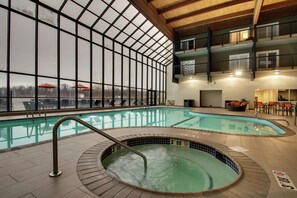 An indoor swimming pool with a view of the outside, a hot tub, and a seating area with tables and chairs. - DoubleTree by Hilton Mt. Vernon (Mount Vernon)