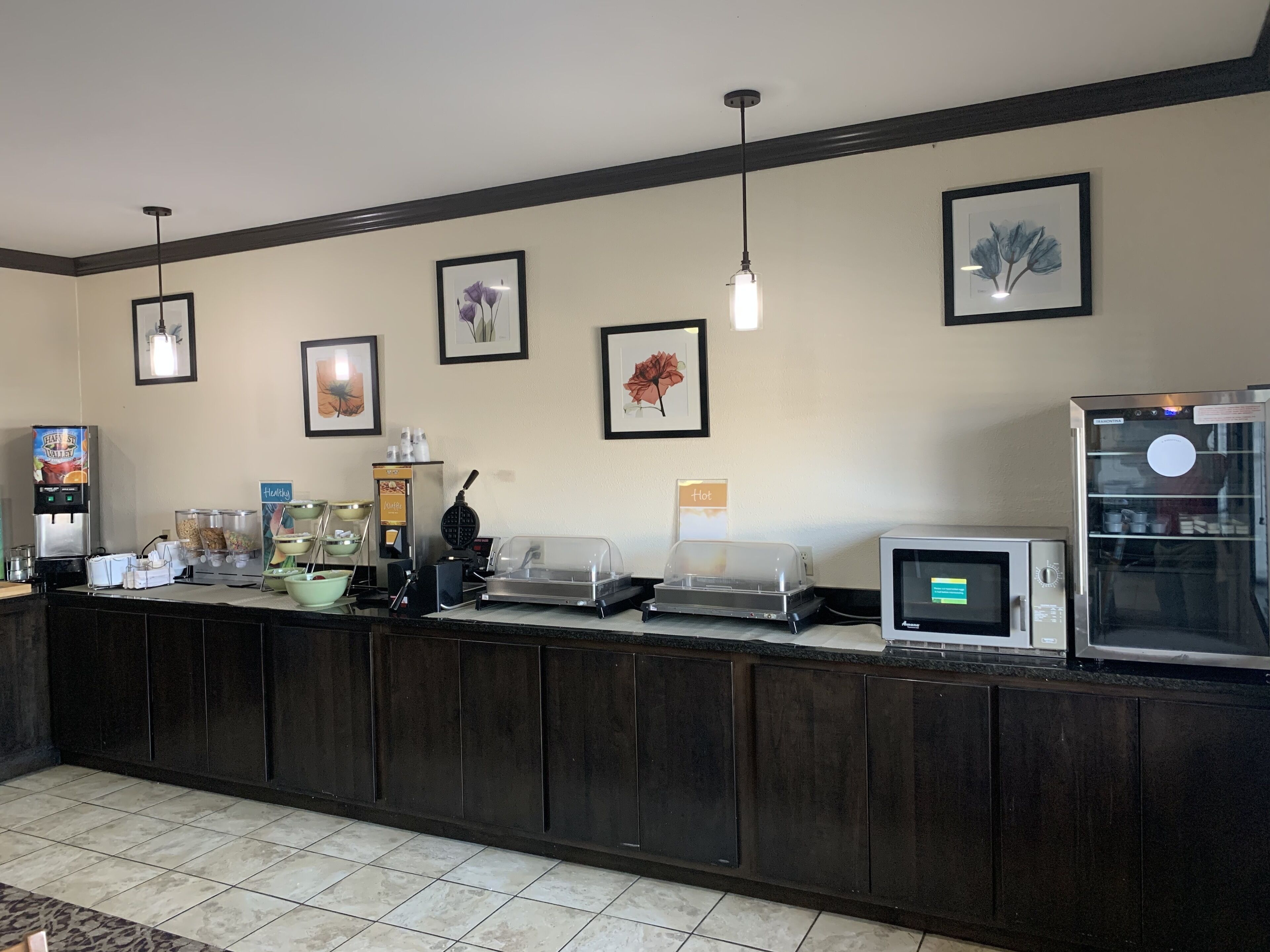 A hotel reception area with a self-service beverage station, a microwave, and a refrigerator.
