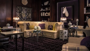 Un salon luxueux, doté d’un canapé moelleux, de lampes décoratives et d’un lustre.
