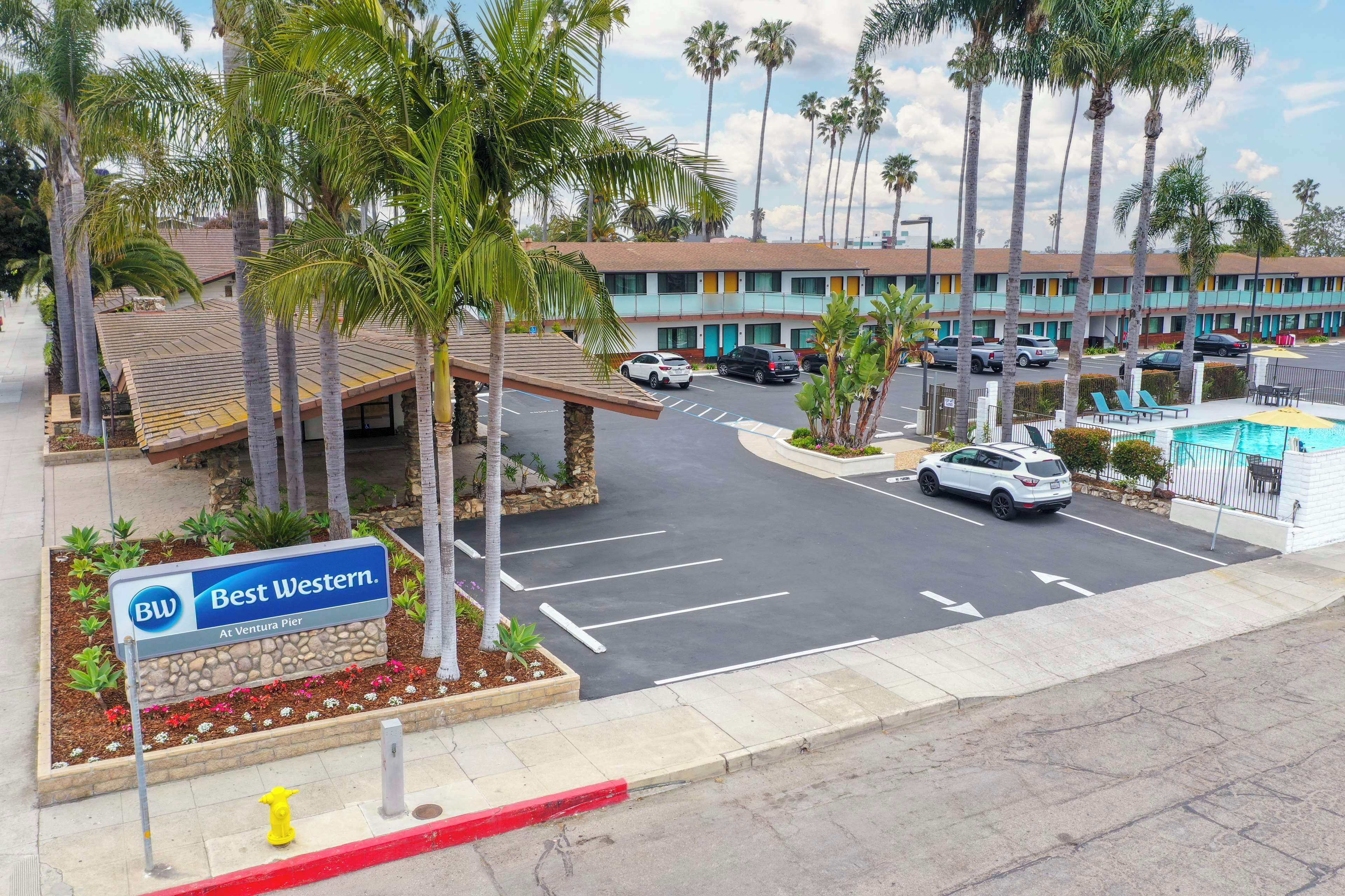 A Best Western hotel at Ventura Pier with a parking lot, palm trees, and a swimming pool.