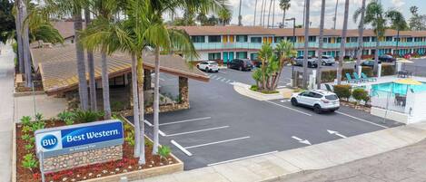 Un hotel Best Western cerca del muelle de Ventura, con estacionamiento, palmeras y piscina.