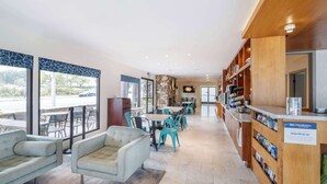 Vestíbulo de hotel con áreas de estar, una recepción y vistas al exterior.