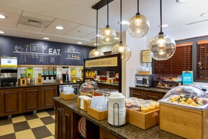 A breakfast buffet area with various food items and a sign that reads "HAPPY BREAKFAST STARTS HERE". - Hampton Inn Winston-Salem Hanes Mall (Winston-Salem)