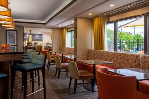 A hotel lobby with seating areas, a bar, and a view of the outdoors. - Hampton Inn Winston-Salem Hanes Mall (Winston-Salem)