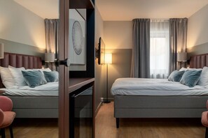 A hotel room with two beds, a desk, and a chair. - Elite Grand Hotel Norrköping (Norrköping)