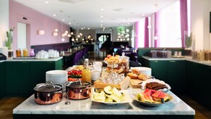 A buffet setup with various food items and beverages on a marble counter. - Elite Grand Hotel Norrköping (Norrköping)