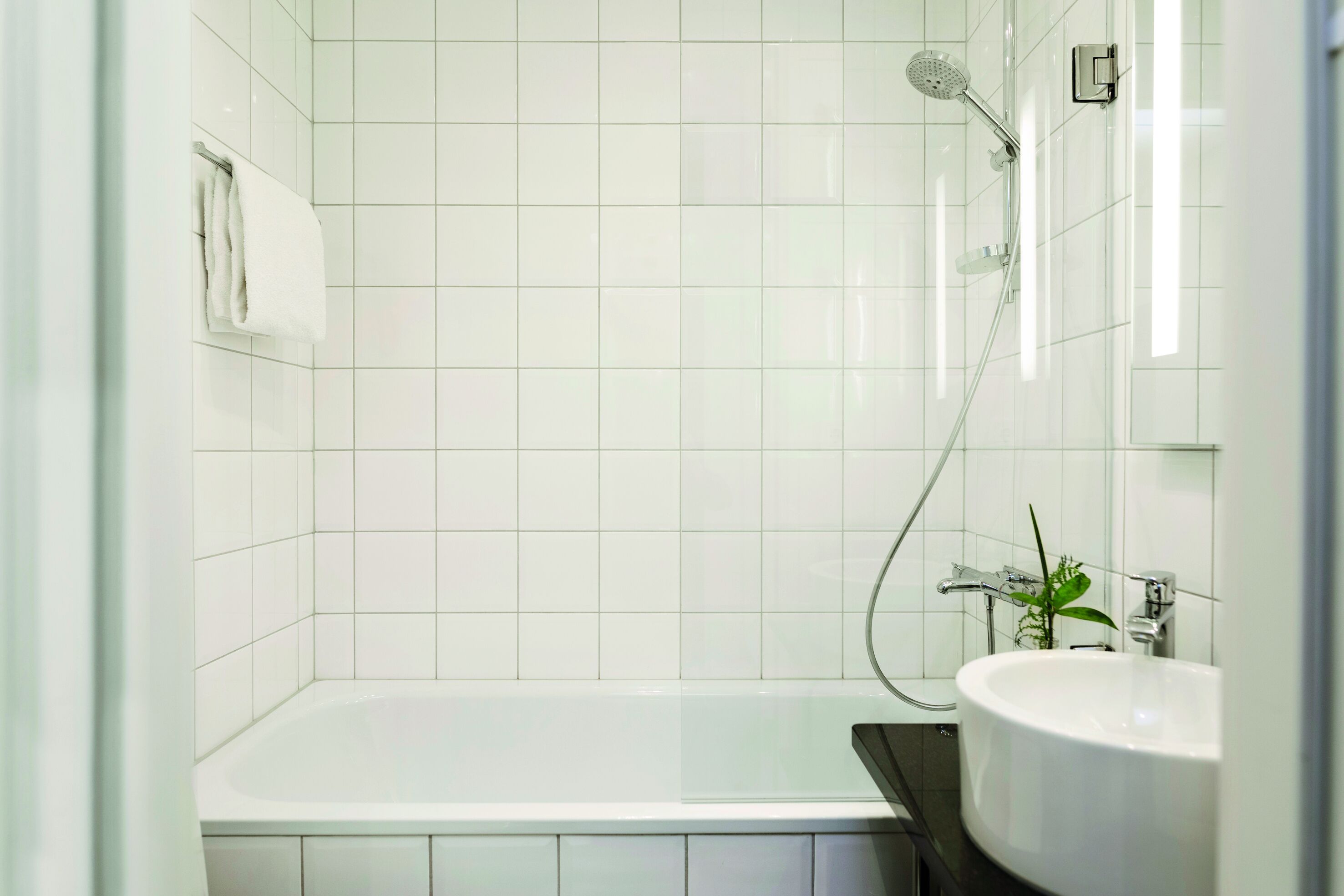A modern bathroom with a bathtub, a shower, and a sink.