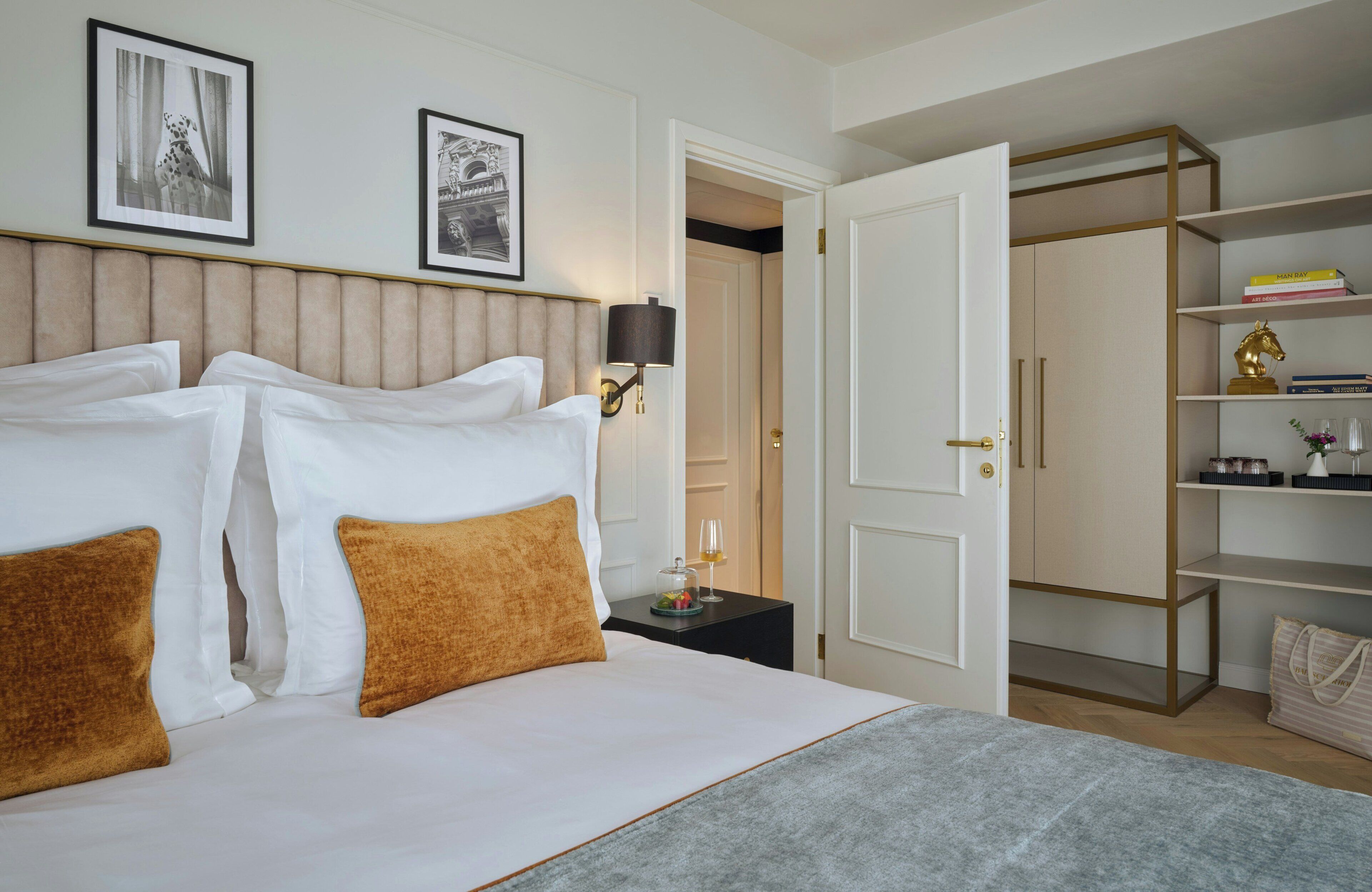 A hotel room with a bed, a nightstand, a lamp, a wardrobe, and a door.